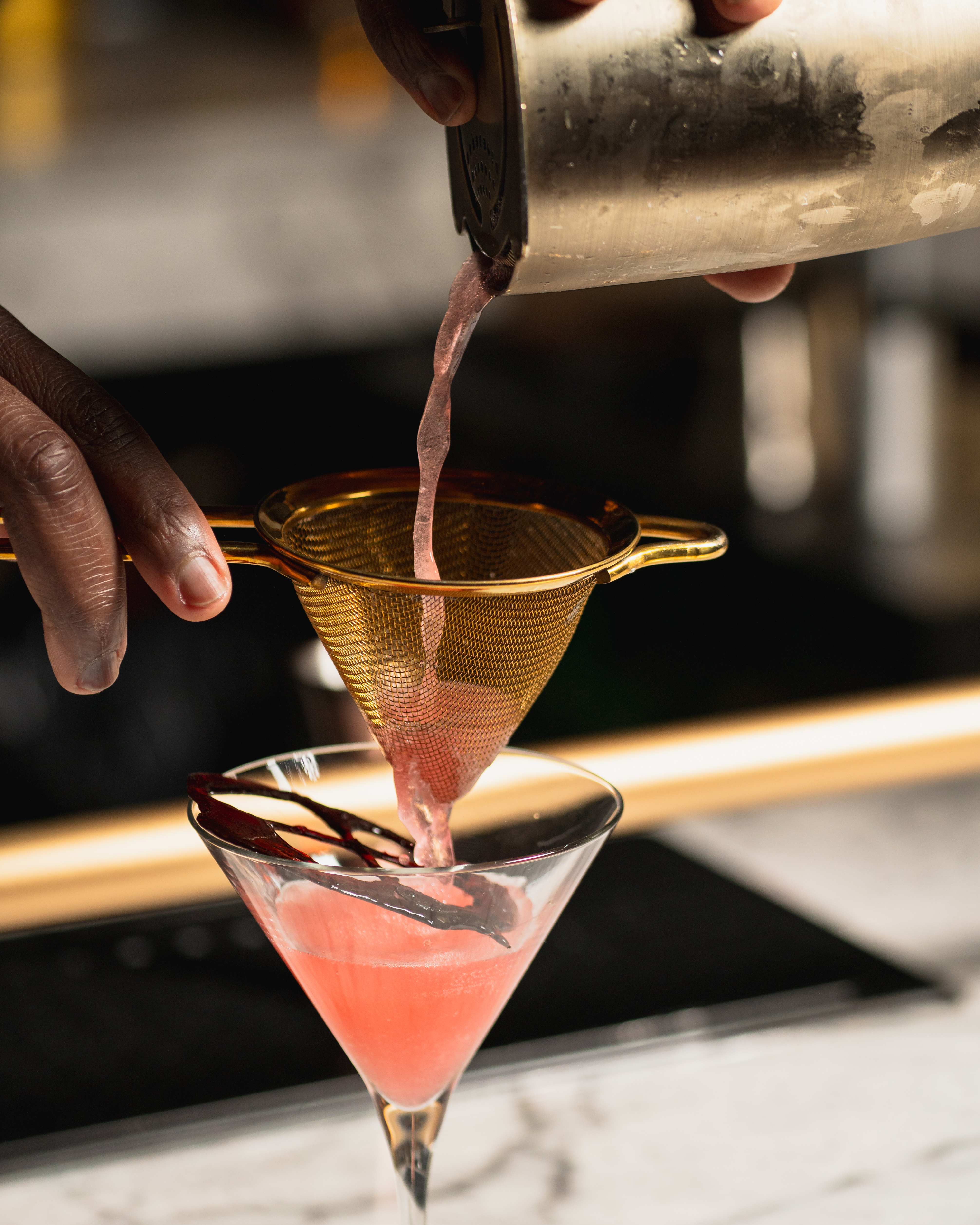 Bartender straining cocktail at Books A Whiskey Society San Antonio